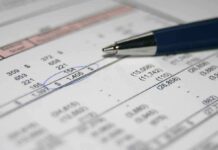 Close-up of a financial document with highlighted numbers and a pen