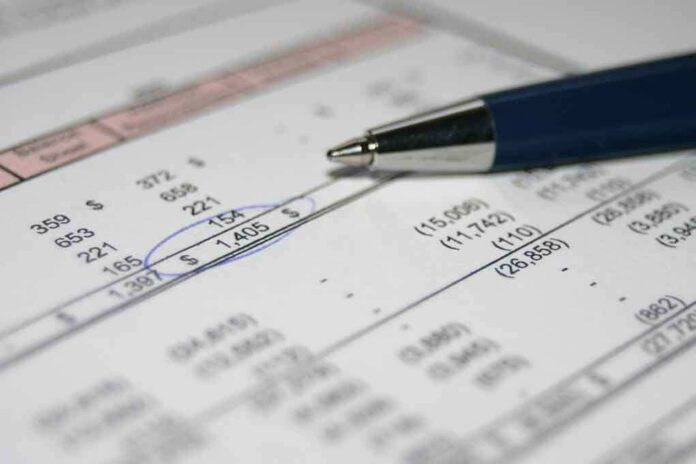 Close-up of a financial document with highlighted numbers and a pen