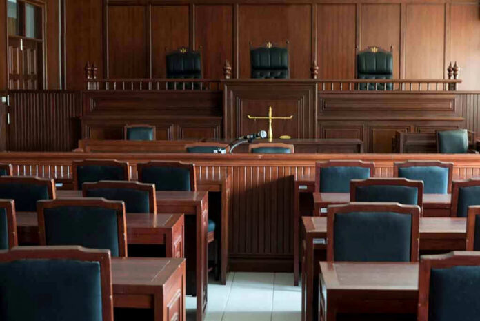 1154521519 Empty courtroom with wooden furnishings and judges bench.