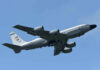 Military aircraft flying in clear blue sky.