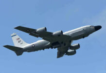 Military aircraft flying in clear blue sky.