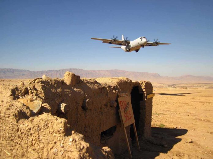 Military aircraft flying over a desert with an abandoned bunker and a for sale sign