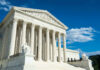 Court Slams Words, Not The Crime Building with columns under a blue sky.