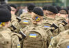The Clock Is Ticking on Putin’s Ukraine Strategy Soldiers in camouflage uniforms with Ukrainian flags.