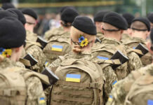 The Clock Is Ticking on Putin’s Ukraine Strategy Soldiers in camouflage uniforms with Ukrainian flags.