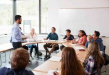 University Condemns Shocking Pro-Terror Post Teacher speaking to students in a classroom discussion