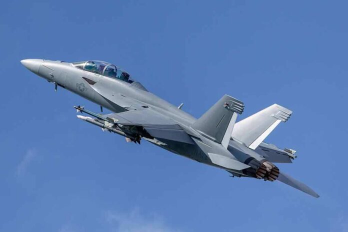 Twin-engine fighter jet climbing in a clear blue sky