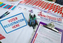 Sixty Losses, Zero Proof Voter registration table with forms, pens, and informational materials