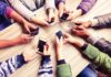 Thousands of SIM Cards Seized in Nationwide Raid Hands around a table holding smartphones