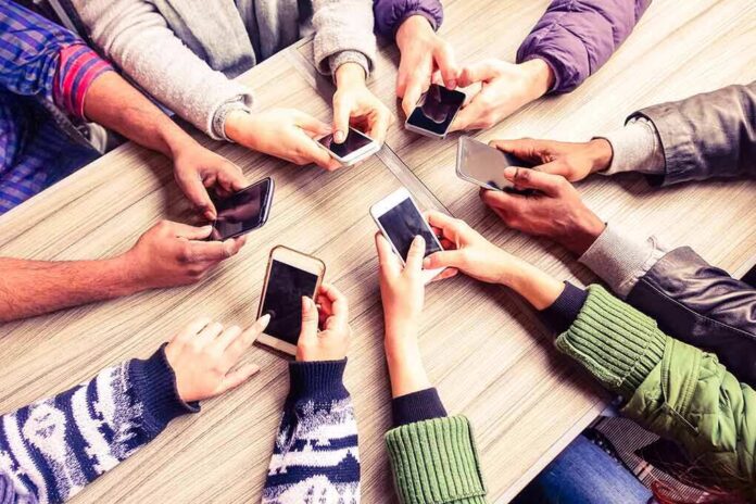 Hands around a table holding smartphones
