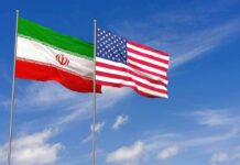 Iran and United States flags waving on flagpoles