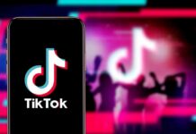 Smartphone showing TikTok logo against neon party silhouettes