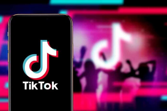 Smartphone showing TikTok logo against neon party silhouettes