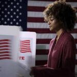 Voter at a polling booth with an American flag backdrop