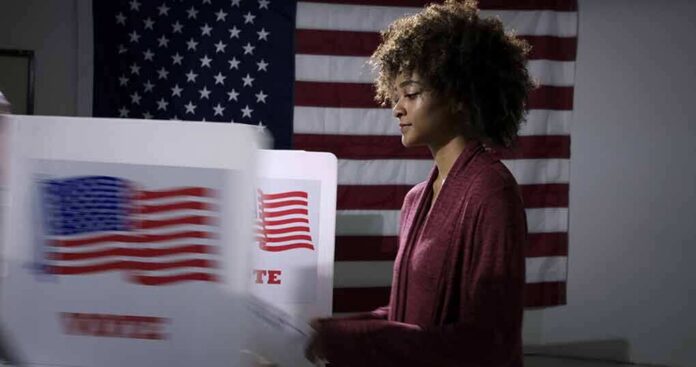 Voter at a polling booth with an American flag backdrop