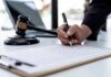 Baby Starved to Death, Parents Get Probation Hand signing legal document beside gavel and laptop