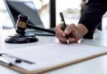 Baby Starved to Death, Parents Get Probation Hand signing legal document beside gavel and laptop