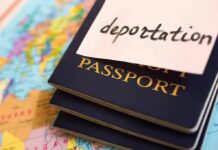 Stack of passports with a note labeled deportation on top, placed on a map