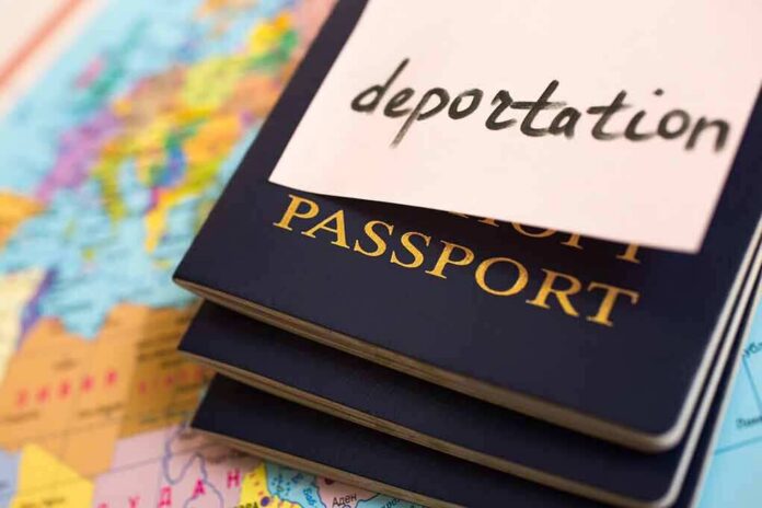 Stack of passports with a note labeled deportation on top, placed on a map
