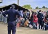 Police officer watching a crowd near a checkpoint