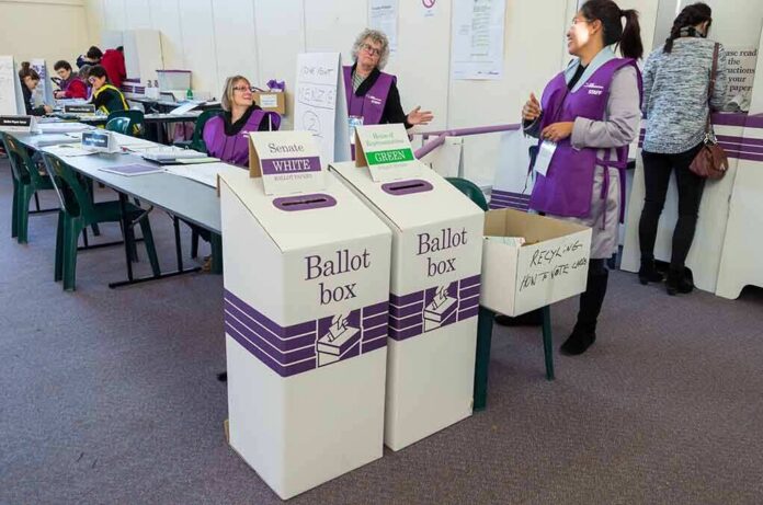 Election workers near ballot boxes in a polling station