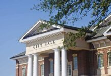 City Defies Top Court – Rights Fight Back Exterior view of a city hall building with columns and a clear blue sky