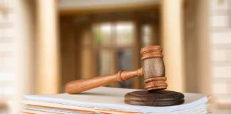 judge's gavel resting on a stack of case files