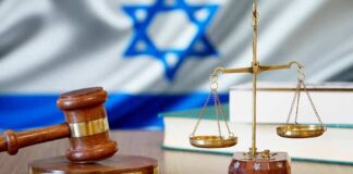 Gavel and scales of justice with Israeli flag in background