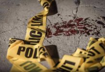 Crime scene tape near blood on pavement