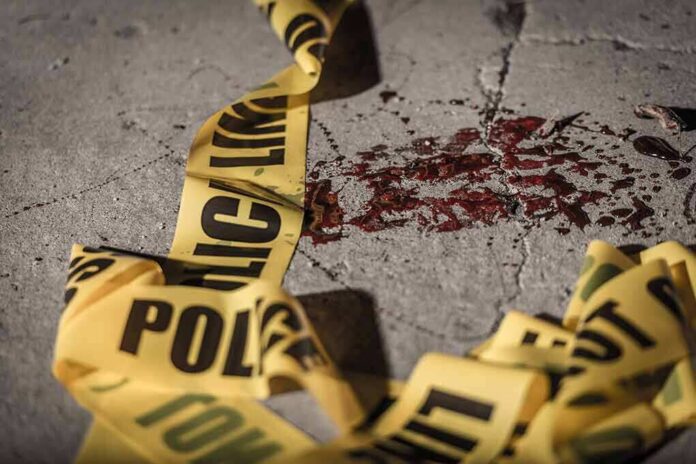 Crime scene tape near blood on pavement