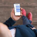 Person holding a smartphone with a messaging app open