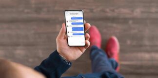 Person holding a smartphone with a messaging app open