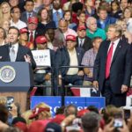 speaker at podium addressing crowd at political rally