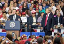 speaker at podium addressing crowd at political rally