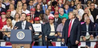 speaker at podium addressing crowd at political rally