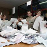 People counting ballots at a table