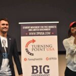 Curro Savoy at a TPUSA event with another speaker on stage