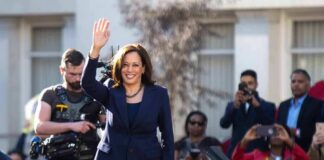 woman in navy suit waving at outdoor event
