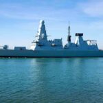 naval destroyer sailing in calm harbor waters
