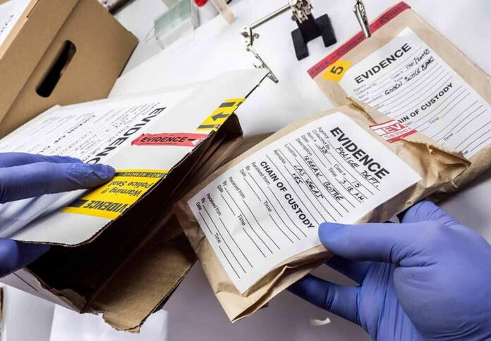 Gloved hands handling labeled evidence bags and boxes