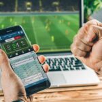 Person checking live soccer betting odds on a smartphone
