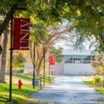 Campus Shuts Down For TPUSA Memorial Tree-lined campus walkway with red banners