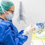 A Surrogacy Case Exposed A Legal Blind Spot medical professional in blue gown putting on sterile gloves