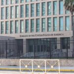 Embassy building behind tall black security fence