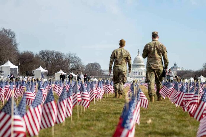 shutterstock_1899676156 Two soldiers walk among American flags toward the U.S. Capitol