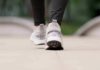 Close-up of person walking in gray sneakers