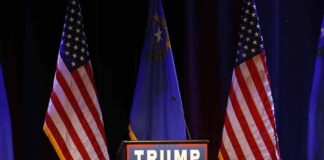 Podium with campaign sign between American flags