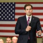 man in suit speaking into a microphone