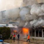 firefighters respond to large building fire with heavy smoke