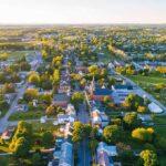 Aerial view of a small town with main street and church at sunset